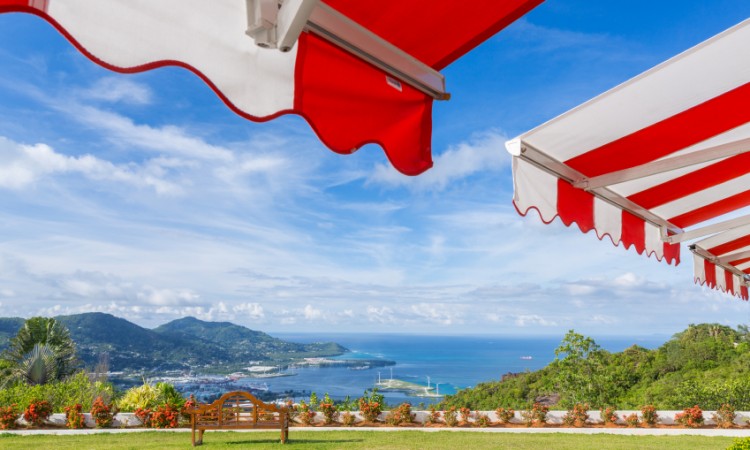 Awning over bright sunny blue sky with bench and sea view