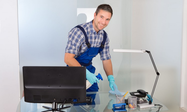 Male Janitor Cleaning Desk